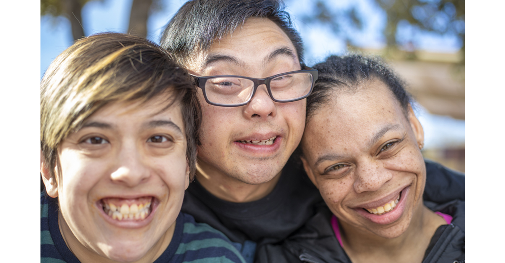 Three people's faces smiling at the camera