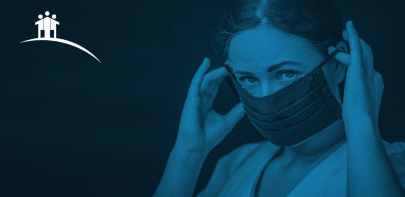 Woman putting on a cloth face mask.